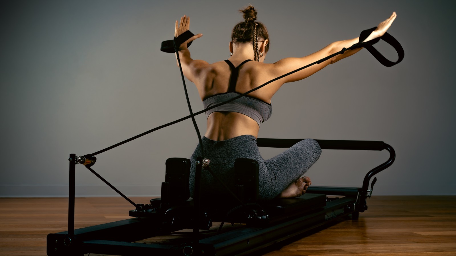 Treino de Pilates em casa: rotina de corpo inteiro de 30 minutos 6 Uma mulher fazendo treino de pilates