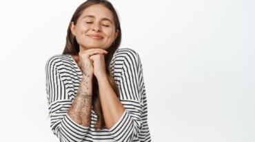 Uma mulher fechando os olhos e sonhando.