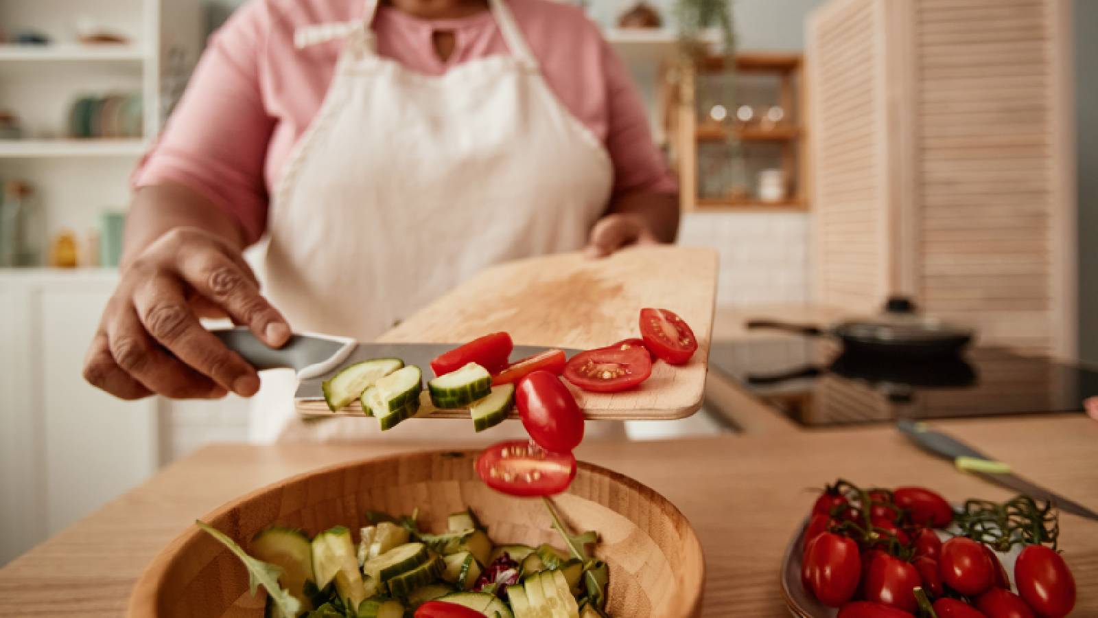 mulher adicionando tomates à salada